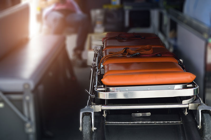 Stretcher in an ambulance with an individual in the background